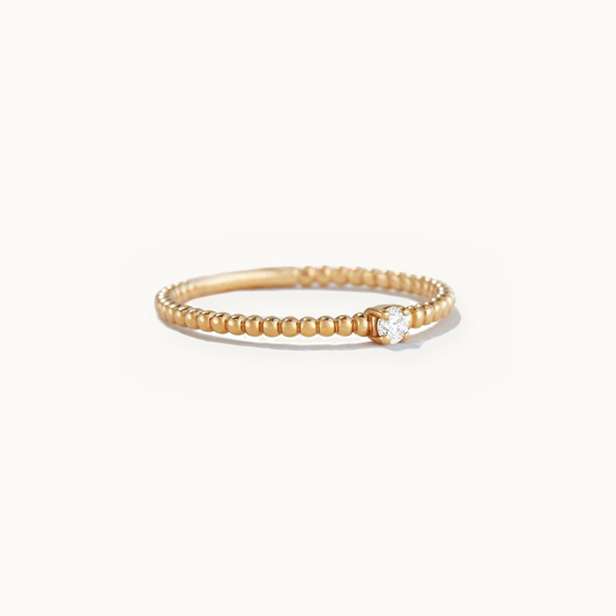 Gold beaded band ring with a single centre stone
