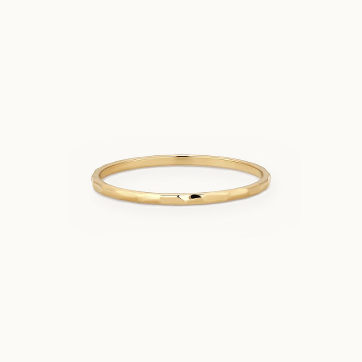 Thin gold band ring with a softly hammered surface