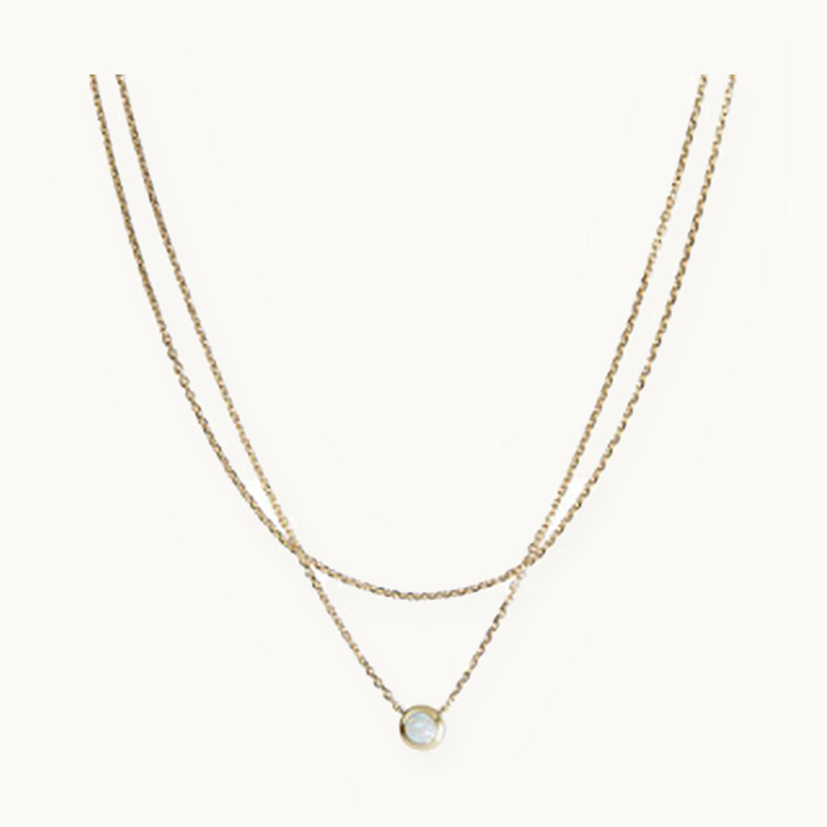 Double layered gold necklace with a single pearl