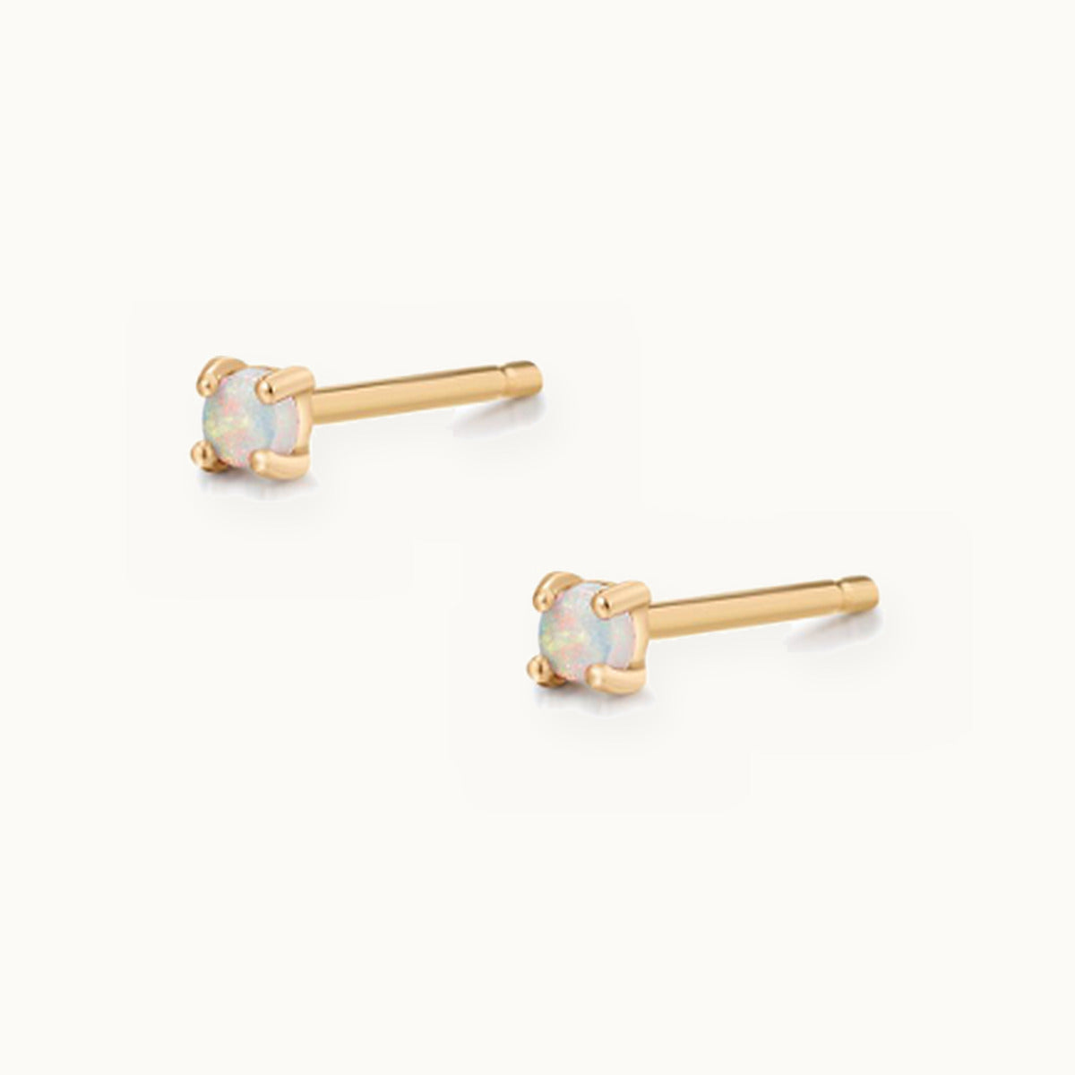 Pair of tiny gold stud earrings with round opals