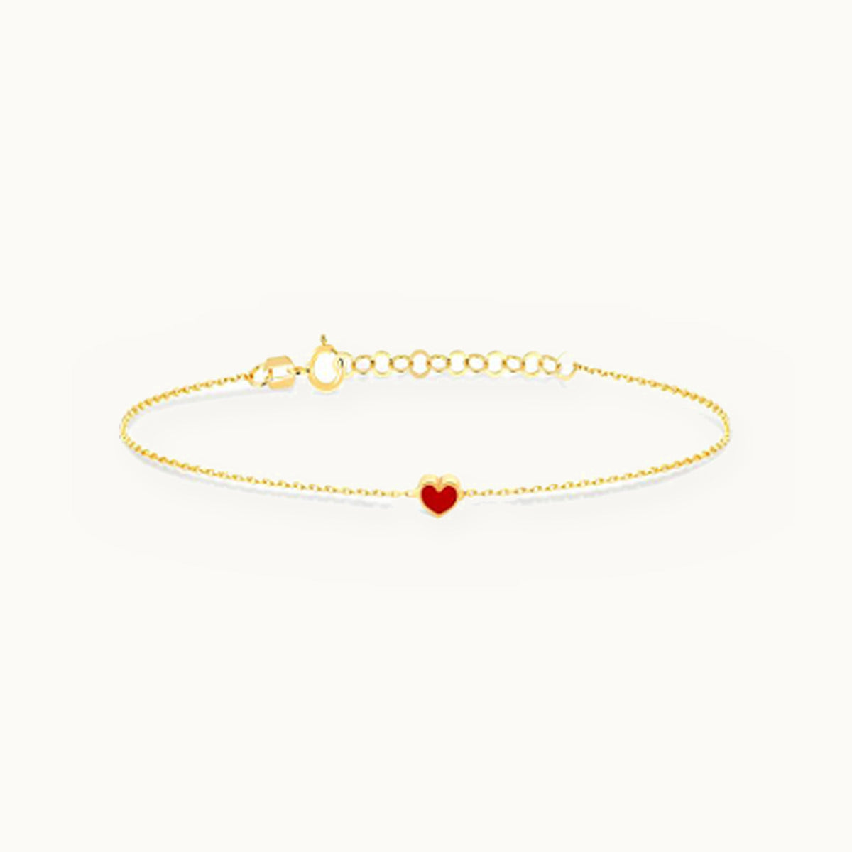 Delicate gold bracelet with a small red heart charm