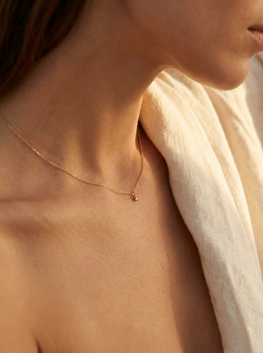 Delicate gold necklace worn on skin