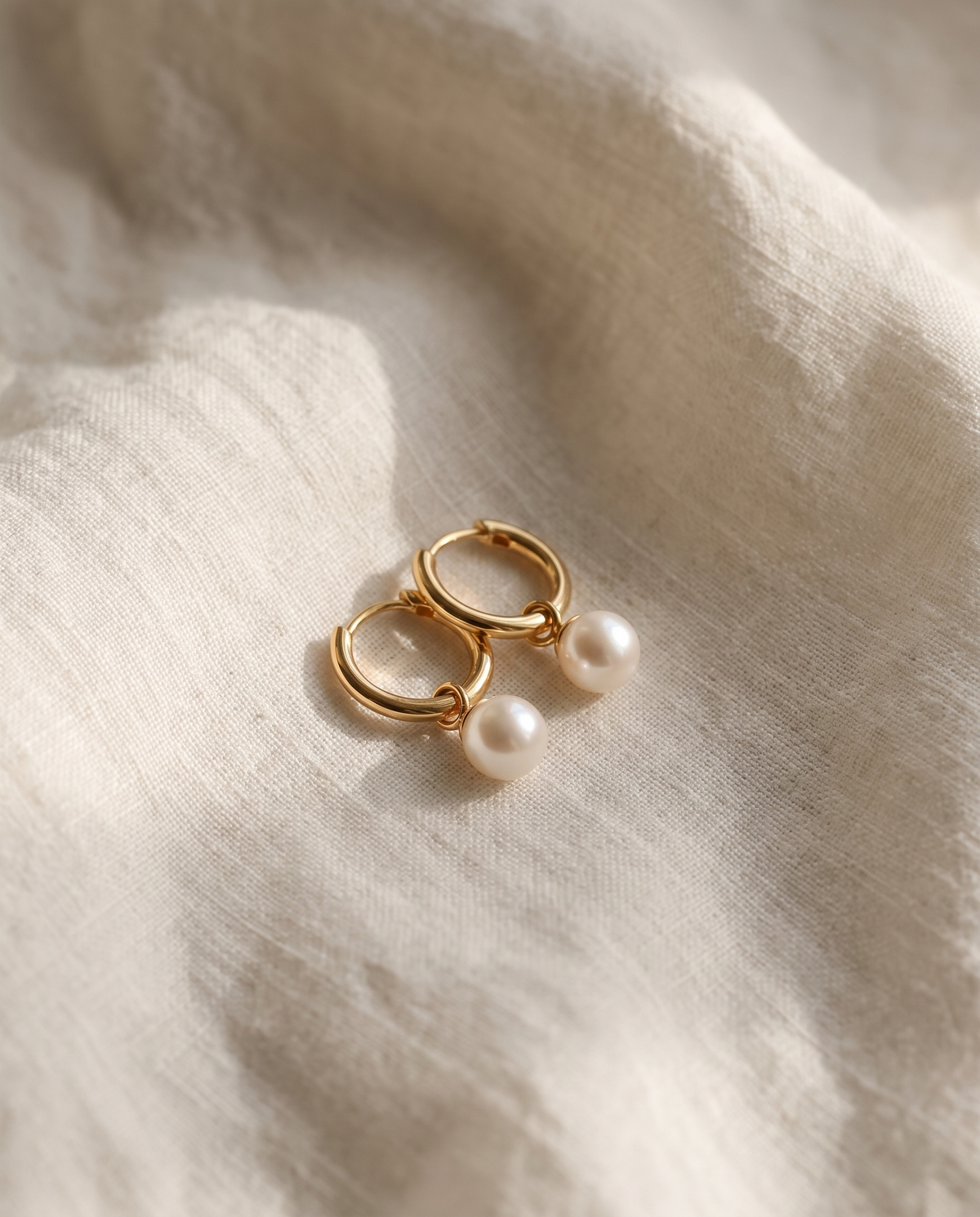 Shell pearl drop earrings in gold vermeil on ivory linen